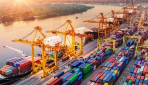 Busy shipping port with colorful cargo containers and yellow cranes at sunset