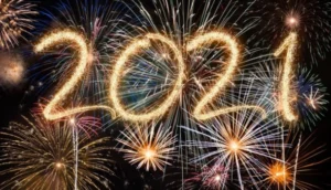 Bright fireworks lighting up the night sky with the number "2021" drawn in sparkling light