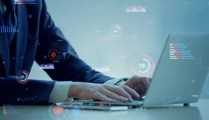 A person in business attire types on a laptop with floating digital charts and graphs overlayed