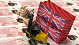 Miniature forklift and stacked cargo containers with Union Jack designs are placed on a background of £50 banknotes