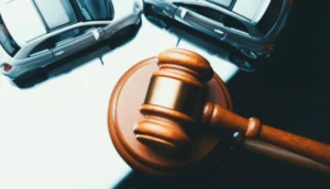 A judge's gavel rests near two model cars