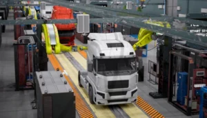 Robotic arms assemble trucks on a modern production line inside a manufacturing facility